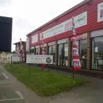 Flags and banners in front of a building with an aluminium panel sign